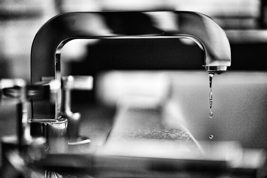 Water drops dripping from a faucet.