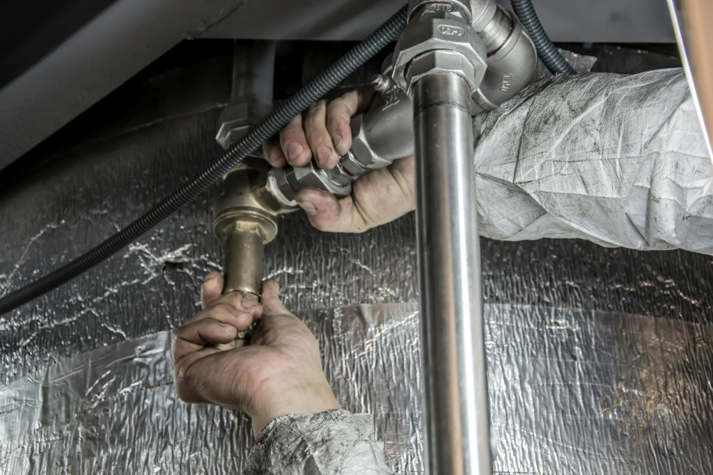 A plumber fixing a water pipe.