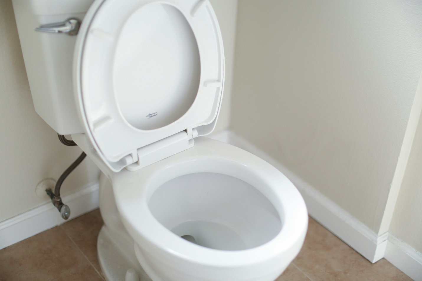 A toilet with the seat up.